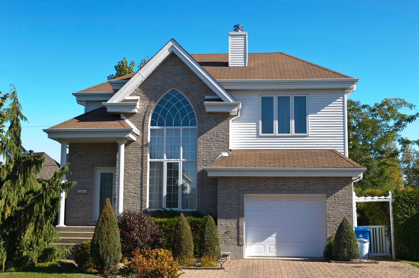 Two-story house plan exterior with stone facade, large arched window, white siding, and attached garage.