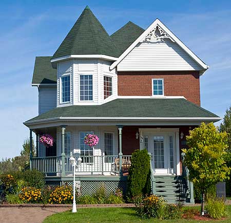 House plan exterior: Two-story home with prominent turret, wraparound porch, gable detailing, and brick and clapboard siding.