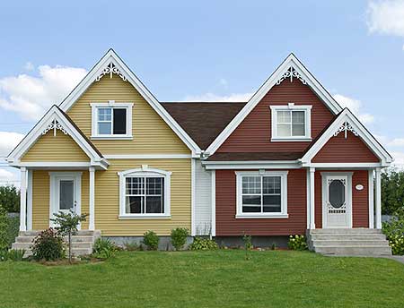 House plan exterior: Two-story duplex with gabled roofs, decorative bargeboards, front porches, and diverse window styles.