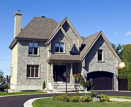 Two-story house plan exterior with stone facade, prominent gables, covered entry porch, and an arched garage.
