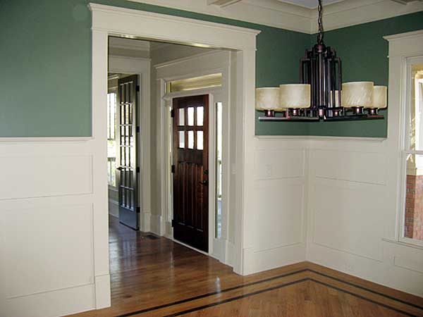 Interior view showing a wood paneled entry with a multi-light chandelier and glass-paneled doors.