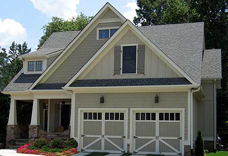 House plan exterior: Two-story Modern Farmhouse with covered porch, prominent gables, and a two-car front-facing garage.
