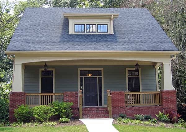 House plan exterior: two-story home with gabled dormer, covered porch with brick supports, and visible rooflines.
