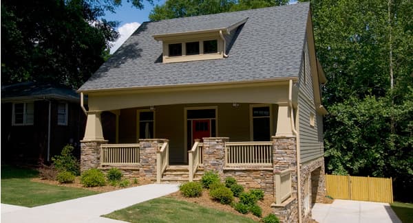 Craftsman house plan exterior with a covered porch supported by stone-clad columns, dormer window, and multi-story design.