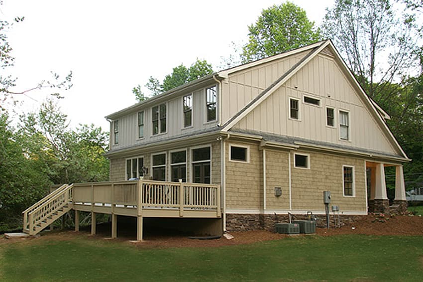 House plan exterior: two-story Modern Farmhouse with large deck, gables, dormers, and stone foundation.