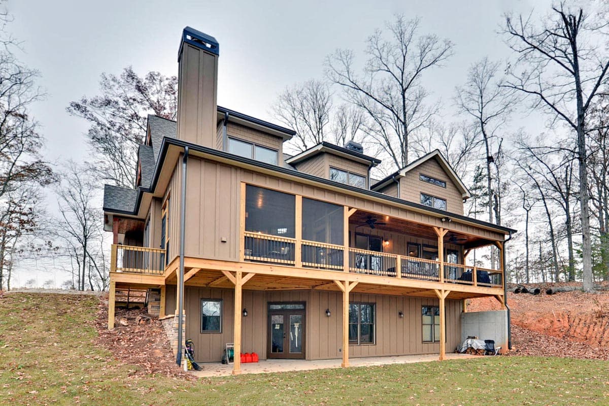 House plan exterior with a large screened porch, multi-level decks, and prominent chimney.
