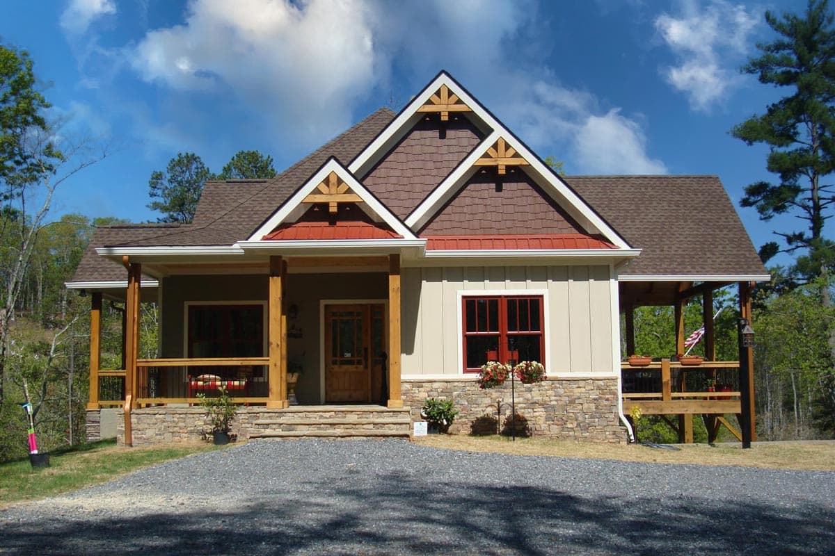 Craftsman-style house plan exterior. Features include a front porch, gabled roof, exposed rafter tails, and a stone facade on the foundation.