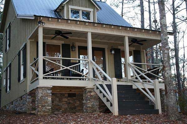 Cottage house plan exterior with metal roof, wraparound porch, stone foundation, and stairs.