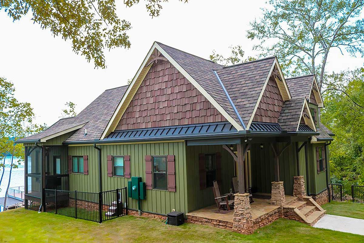 House plan exterior: One-and-a-half story with multiple gables, shingle-accented dormers, and a covered porch with stone supports.