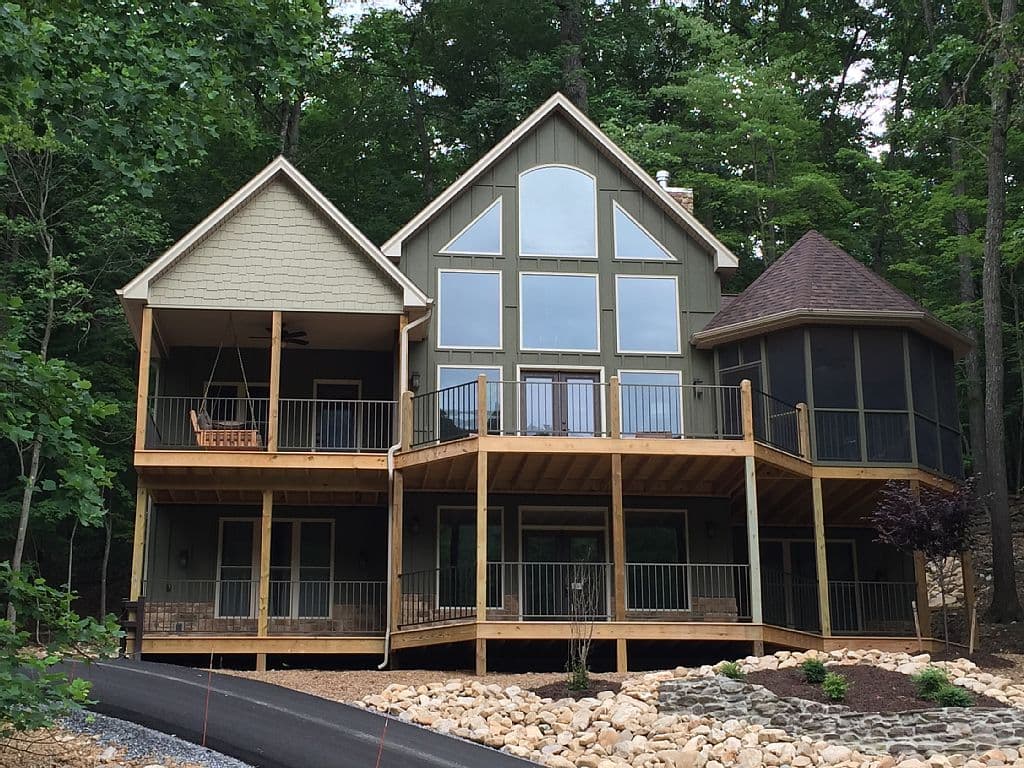 House plan exterior features a two-story design with a prominent gable, multiple decks, and a screened-in octagonal porch.