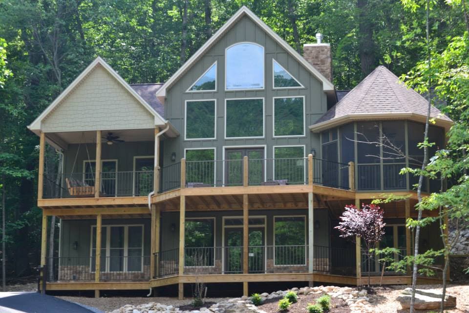 House plan exterior: Modern style, two stories, large multi-pane windows, multiple decks, screened porch, and gables.