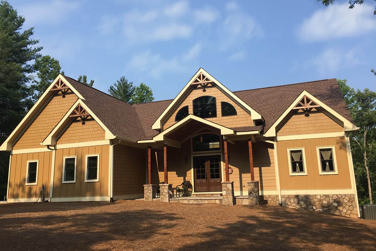 House plan exterior, 1.5 stories, with gable dormers, stone foundation, and covered entry.