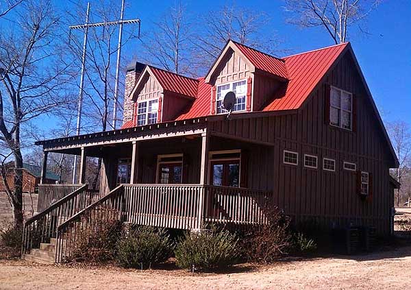 Craftsman style house plan exterior with a wraparound porch, dormers, and a prominent gable with stone chimney.