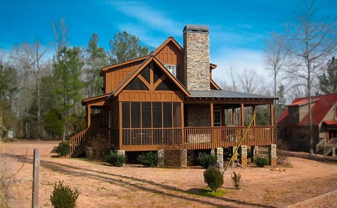 Craftsman house plan exterior with a screened porch, stone chimney, gables, and wraparound porch.