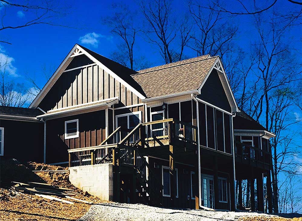 House plan exterior with gables, vertical siding, screened porch, and elevated deck.