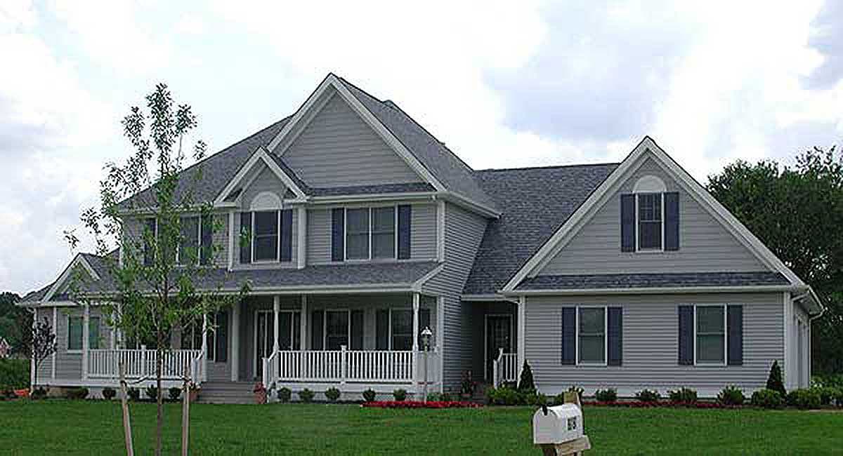 House plan exterior: two-story home with a wraparound porch, multiple gables, and dormer windows.