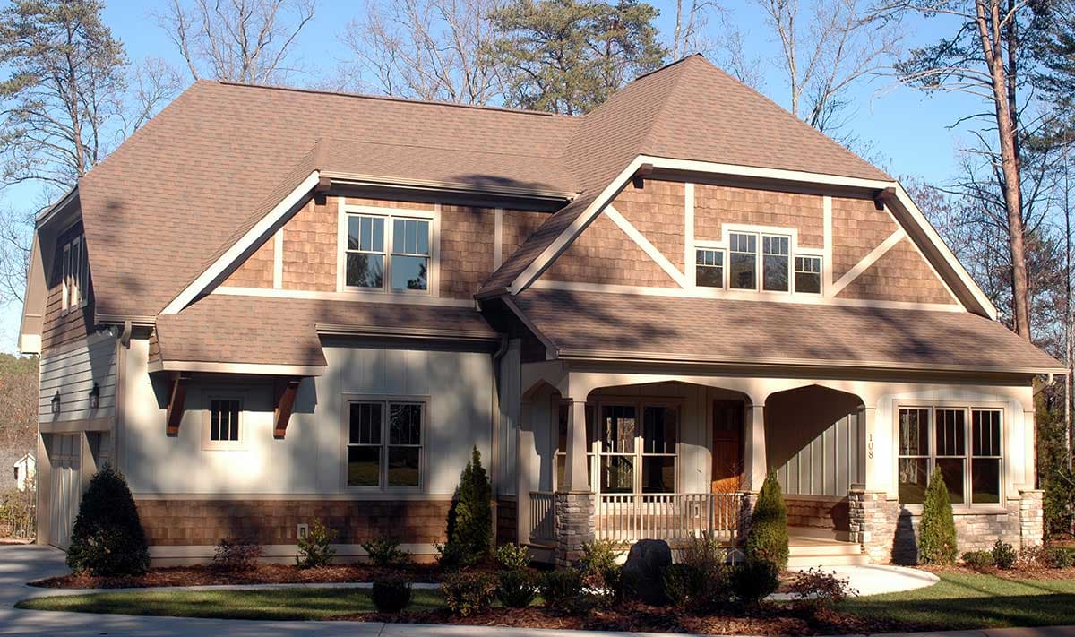 Craftsman house plan exterior with a covered front porch, stone accents, and varied rooflines.