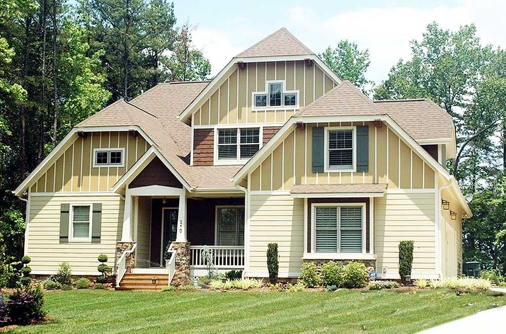 House plan exterior: Two-story home with a covered front porch, multiple gables, and vertical siding accents.