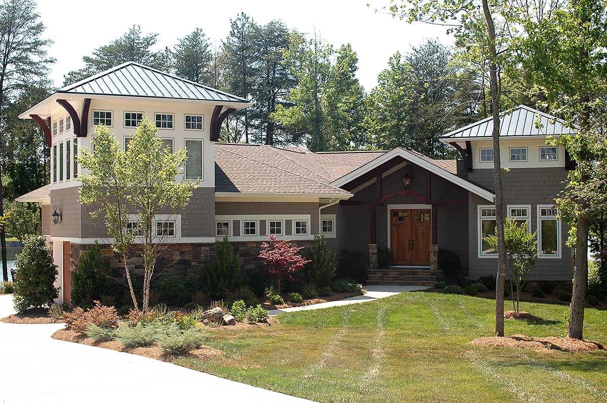 House plan exterior with a prominent gable entry, stone and shingle siding, and multiple towers with metal roofs.