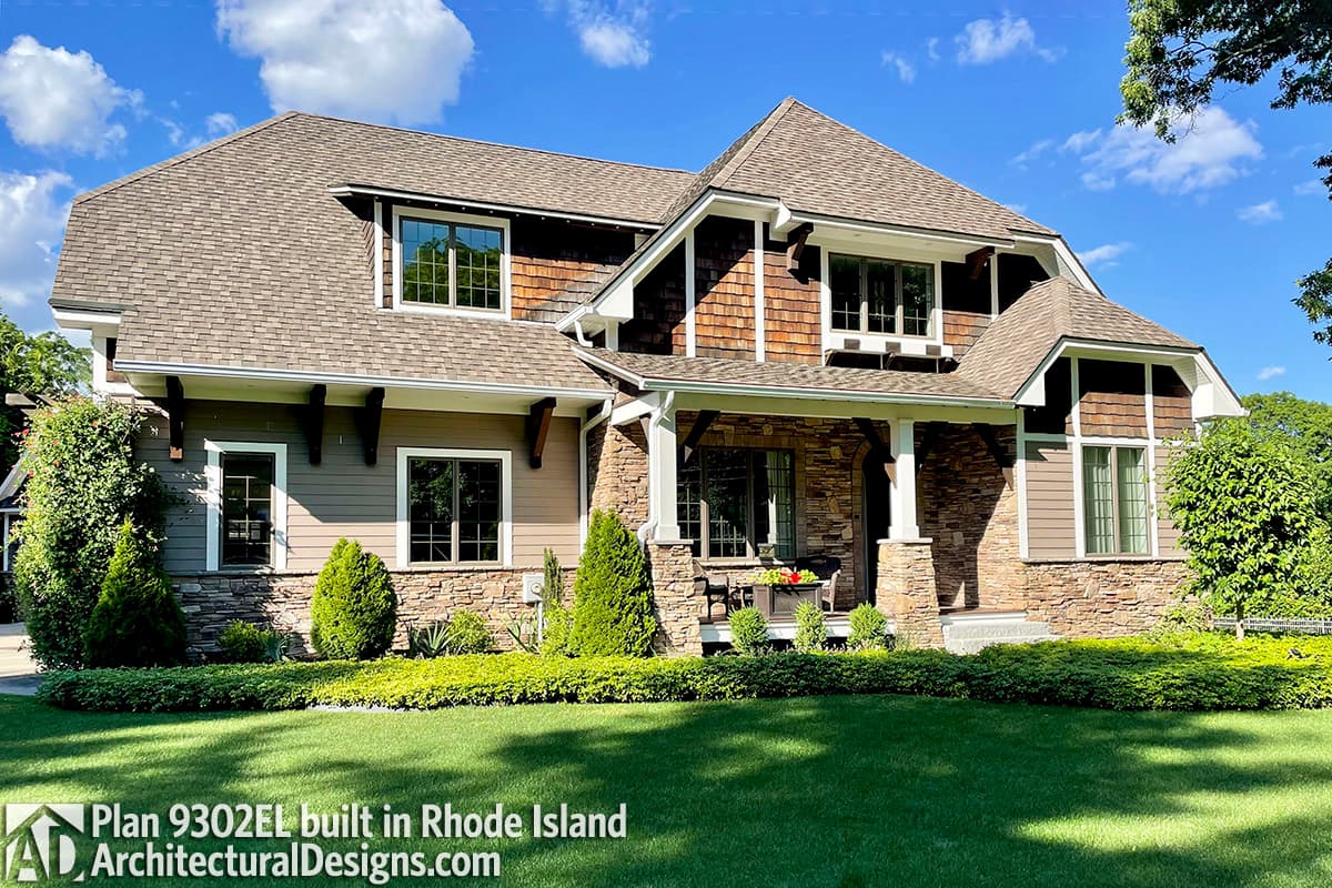 House plan exterior of two-story home with stone and shingle siding, prominent gables, and a covered front porch.