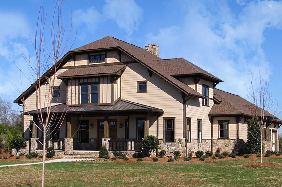 Craftsman style house plan exterior. Features include a front porch with stone columns and a gabled roof. Two-story with dormers and stone accents.