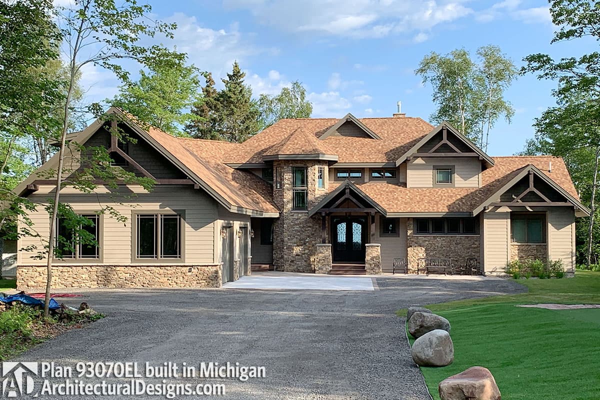 House plan exterior with multiple gables, stone and siding, prominent entry porch, and attached garage.