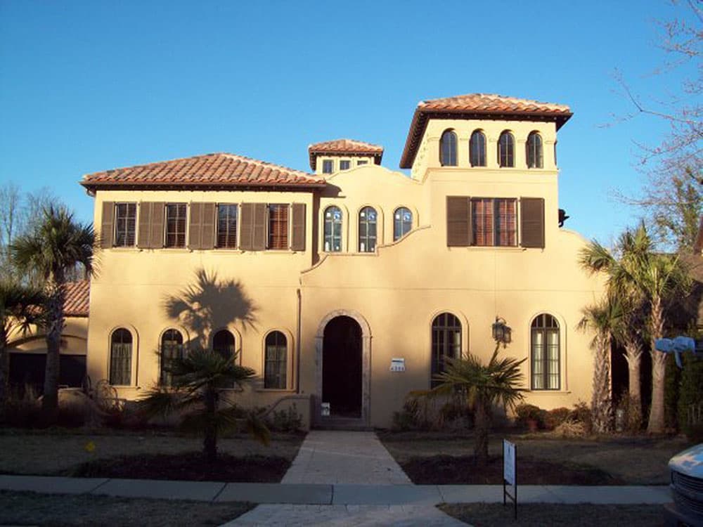 House plan exterior: Mediterranean style, stucco finish, arched entryway, multiple arched windows, and red tile roof.