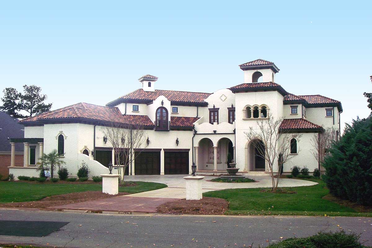 Mediterranean style house plan exterior with stucco finish, tile roof, arched windows, multiple gables, and a central tower.