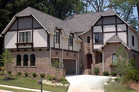Tudor-style house plan exterior with brick and stucco facade, multiple gables, and attached garage.