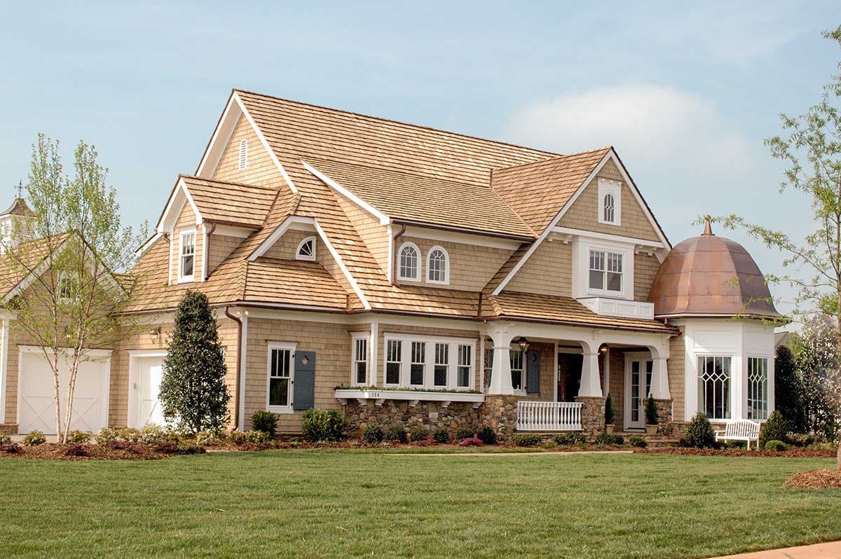 House plan exterior: Two-story Shingle style with multiple gables, dormers, wraparound porch, and copper cupola.