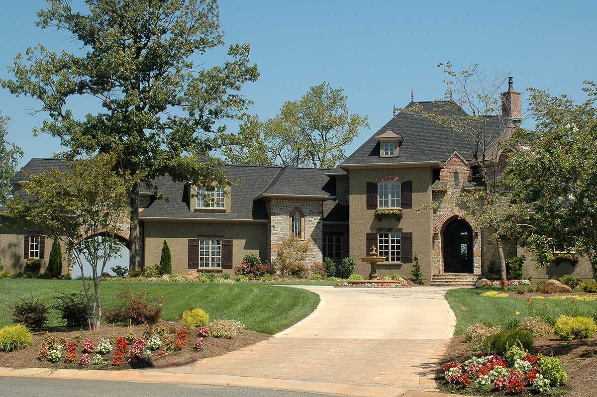 House plan exterior: French Provincial style, two-story with arched entry, dormers, gables, and a fountain.