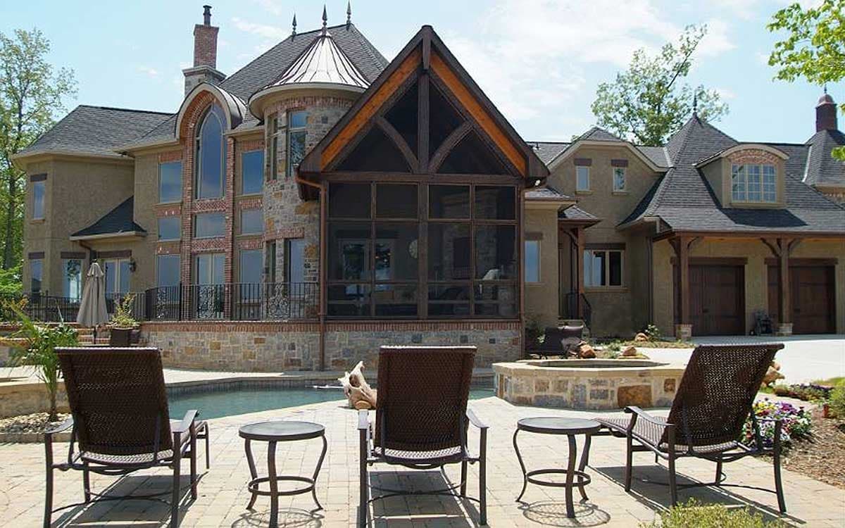 Exterior house plan featuring a screened porch with gabled roof, turrets, arched windows, and attached garage.