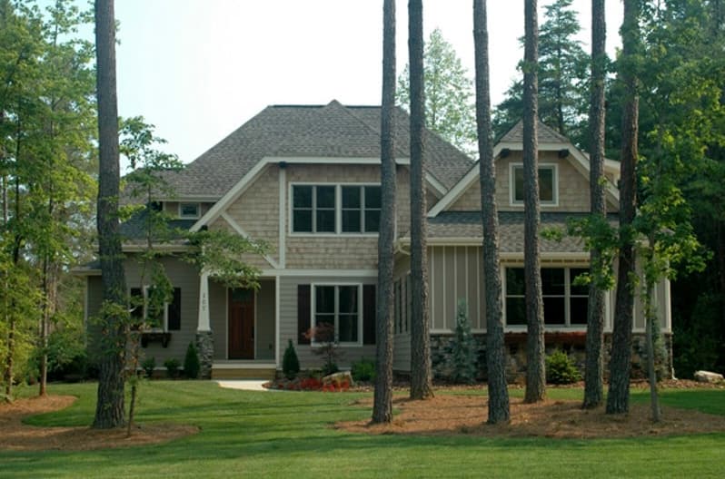 House plan exterior: Two-story home with prominent gables, stone accents, and a covered front porch with stone columns.