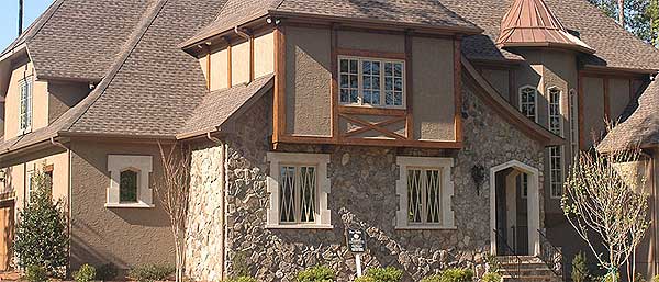House plan exterior with stone facade, stucco siding, multiple gables, dormers, and a turretted roof.