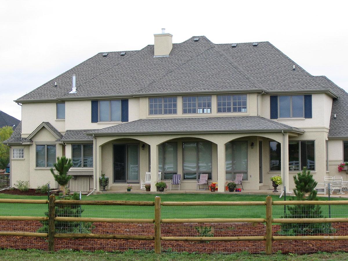 House plan exterior: two-story home with a covered arched porch, multiple gables, and a hip roof.