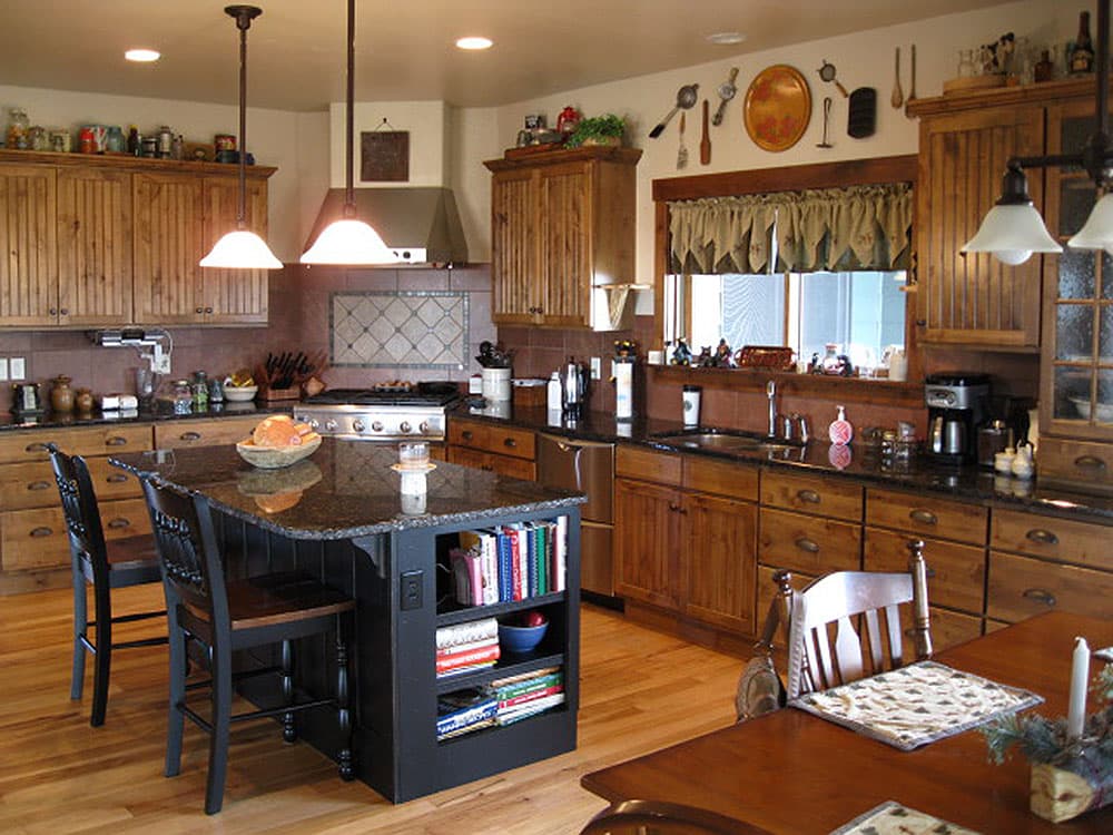 Kitchen with island, granite countertops, wood cabinets, stainless steel range, and decorative backsplash.