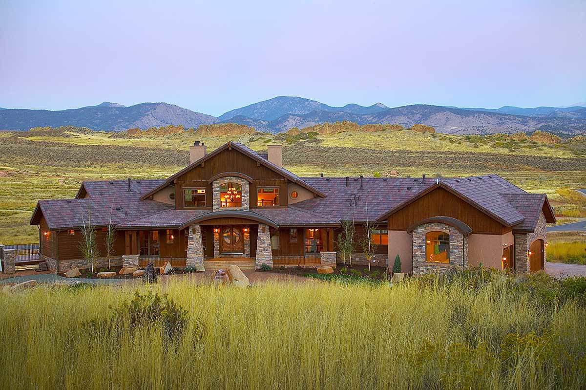 House plan exterior: Wood and stone accents, arched entryway, multiple gables, and expansive rooflines.