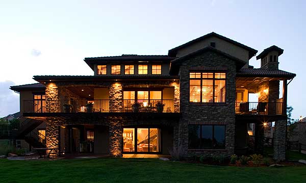 House plan exterior with stone accents, multiple balconies, and a sloping roofline.