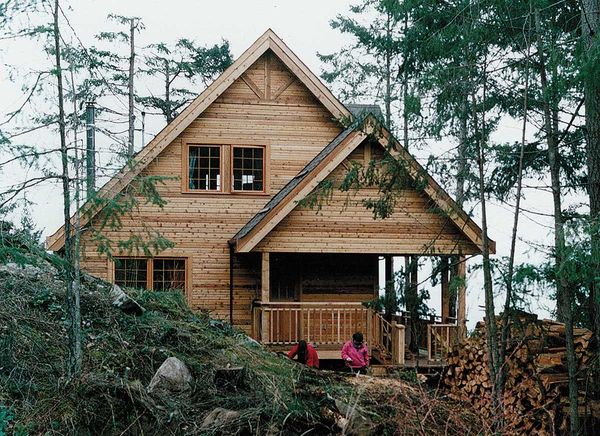 House plan exterior: Wood-sided two-story house with front porch, gables, and dormer windows.