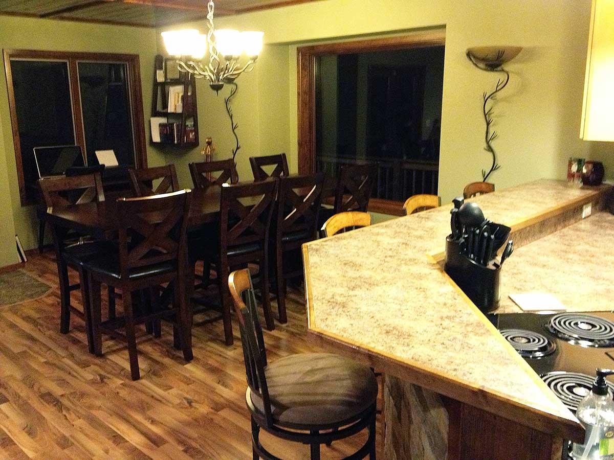 Kitchen with dining table, bar seating, wood floors, and wood ceiling.