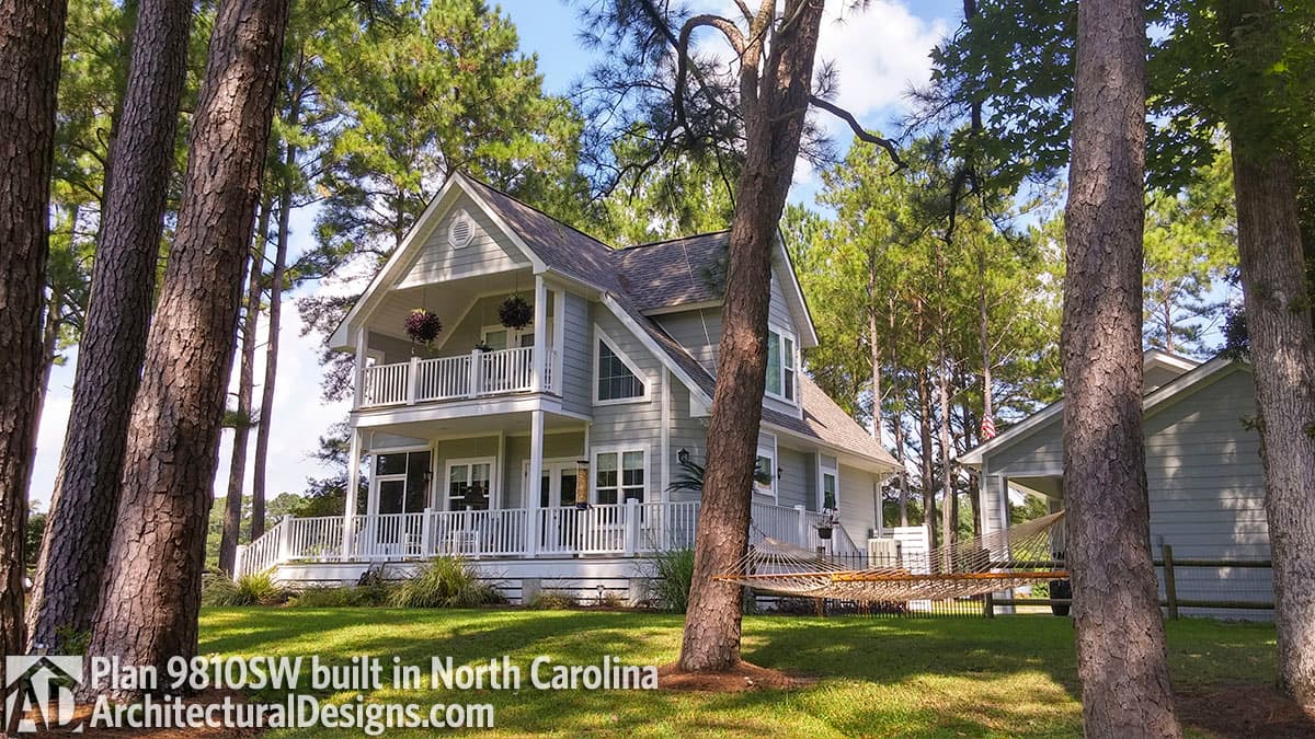 House plan exterior. Two-story, Craftsman-style house with a covered porch, gabled roof, and balcony. Features a detached garage.