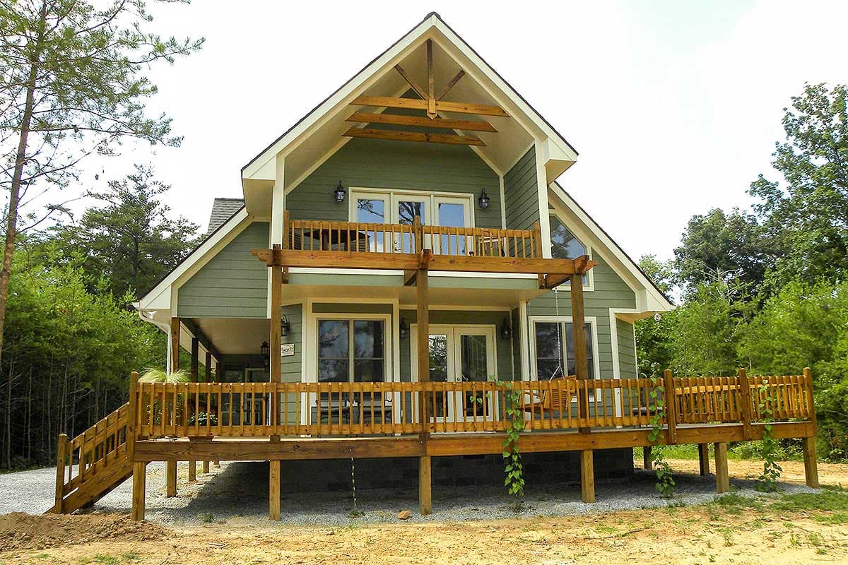 House plan exterior: two-story Modern Farmhouse with wrap-around decks, exposed rafter tails, and large gable.