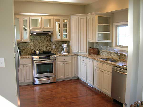 Kitchen with cream cabinetry, granite countertops, stainless steel appliances including a gas range, and hardwood flooring.
